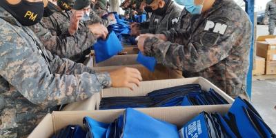 Personal militar embalando kits con medicamentos para pacientes leves con COVID-19