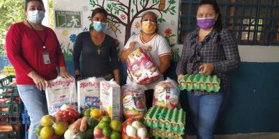 Padres de familia reciben alimentos para sus hijos.