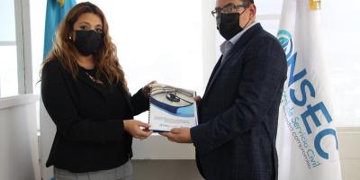La Directora de la Onsec entrega el acuerdo firmado al Director de Puestos y Remuneraciones