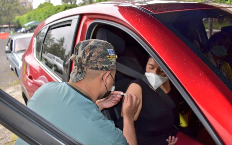 Enfermero militar inmunizando en puesto de vacunación vehicular.