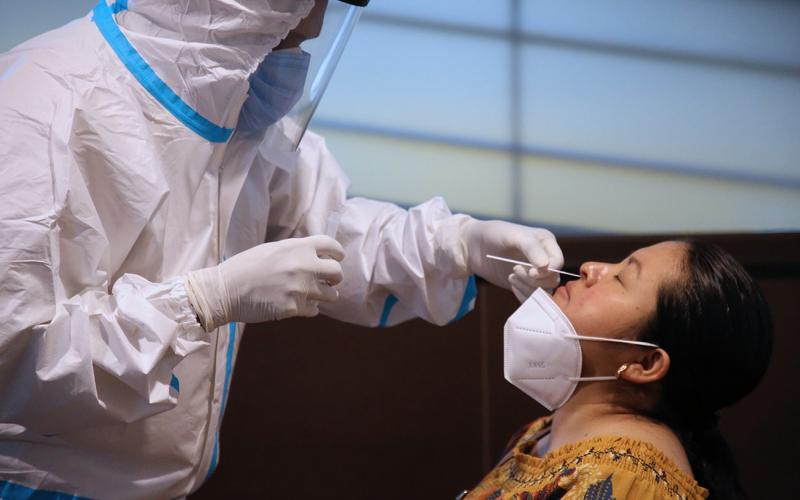 Médico tomando muestra de hisopado para prueba de COVID-19
