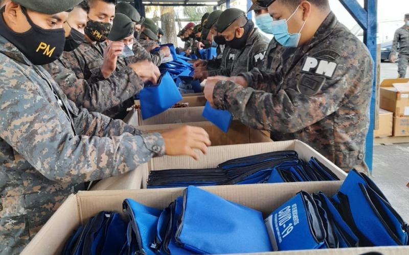 Personal militar embalando kits con medicamentos para pacientes leves con COVID-19
