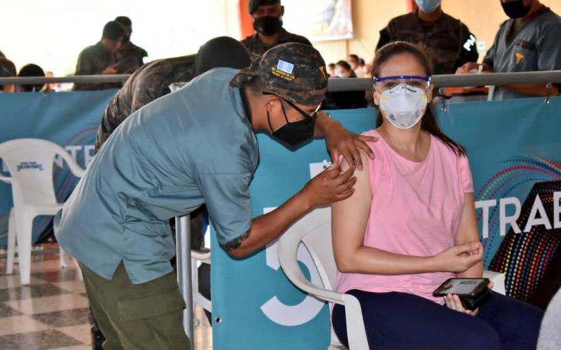 Personal militar coloca vacuna.