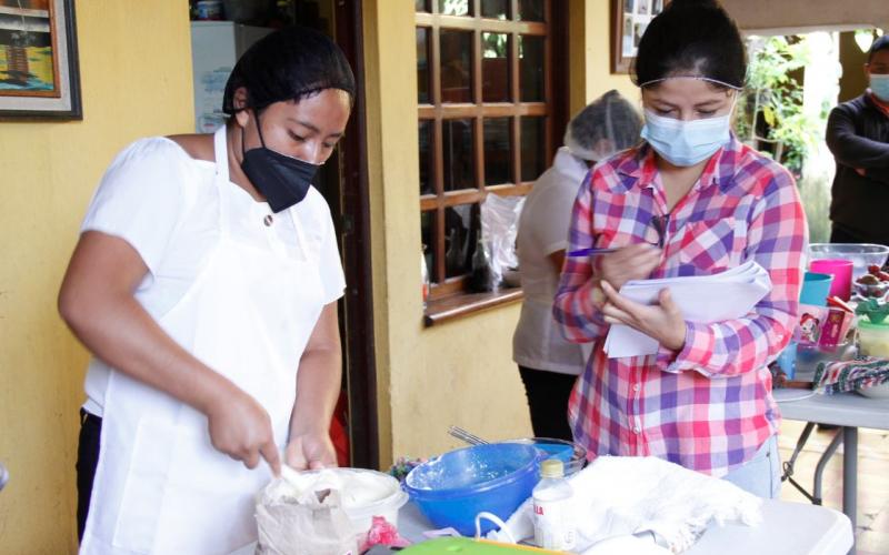 Una de las beneficiarias de SOSEP es evaluada para obtener certificado como cocinera profesional.