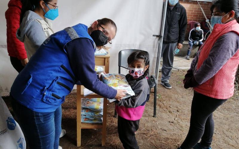 Personal Mides entregando alimento a niña