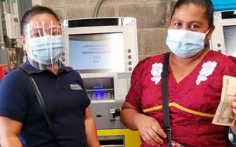 Personal de Mides asistiendo a usuaria de Bono Familia