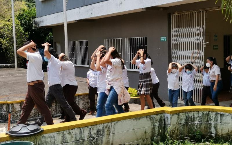 Estudiantes del Centro de Estudio Nueva Familia evacúan las instalaciones, como parte del simulacro desarrollado en la capacitación.
