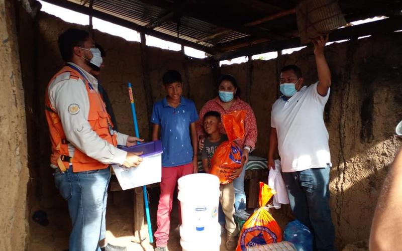 Entrega de ayuda humanitaria a familia afectada por lluvias.