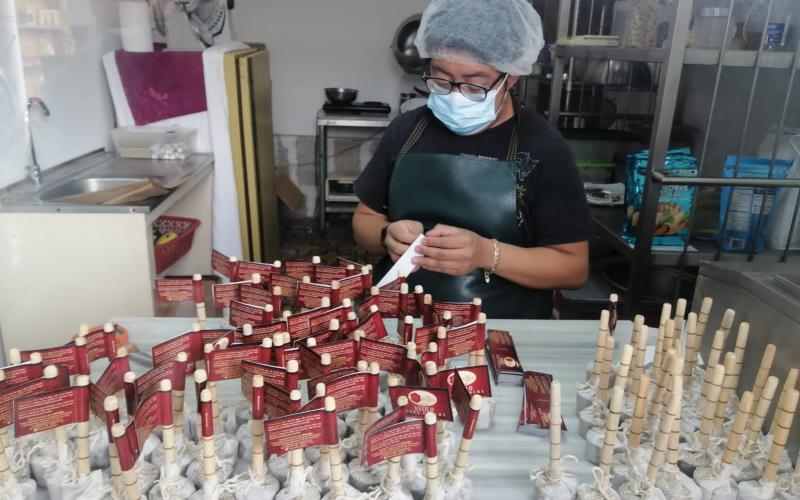 Una operaria elabora chocolate instantáneo cuya particularidad es que posee  su propio molinillo.