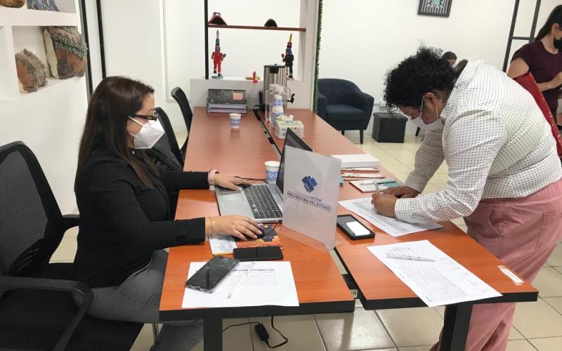 Mujer recibe instrucción por parte de otra persona sobre capacitación para ser proveedora del Estado