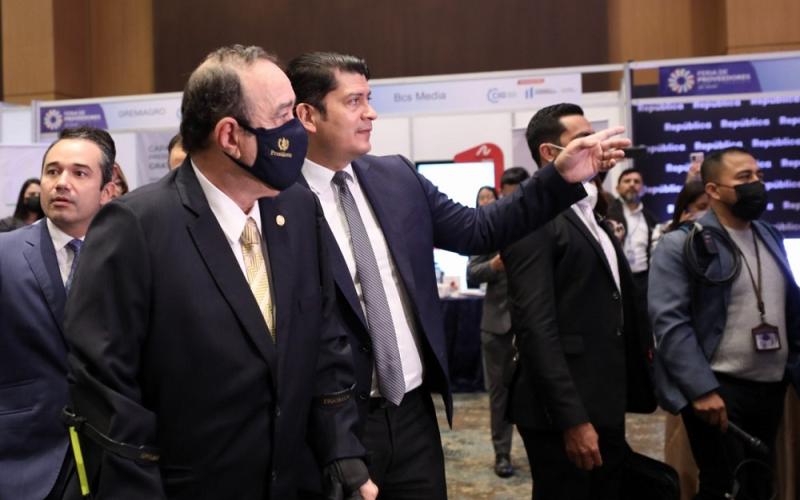 El ministro de economía, Dr. Janio Rosales acompaña al presidente Giammattei duranrte el recorrido de stands, en el Congreso Industrial.