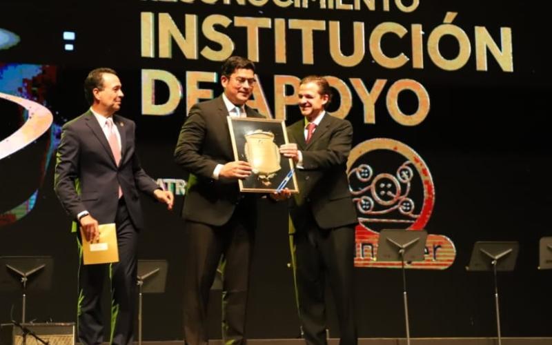 El Ministro de Economía Dr.  Janio Rosales (centro) recibe el reconocimiento.