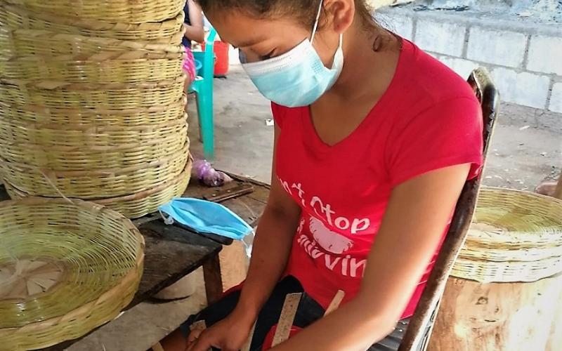 Mujer elabora canastas artesanalmente.