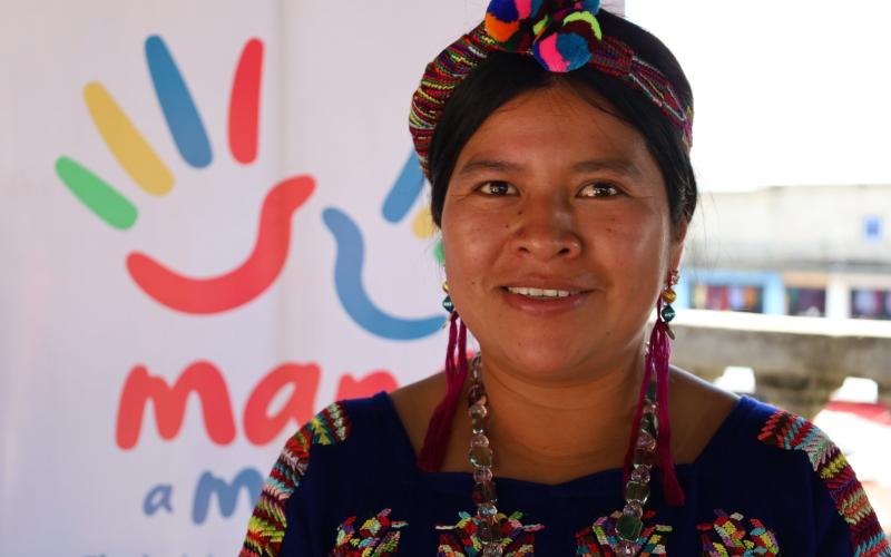 Mujer Indígena con banner institucional.