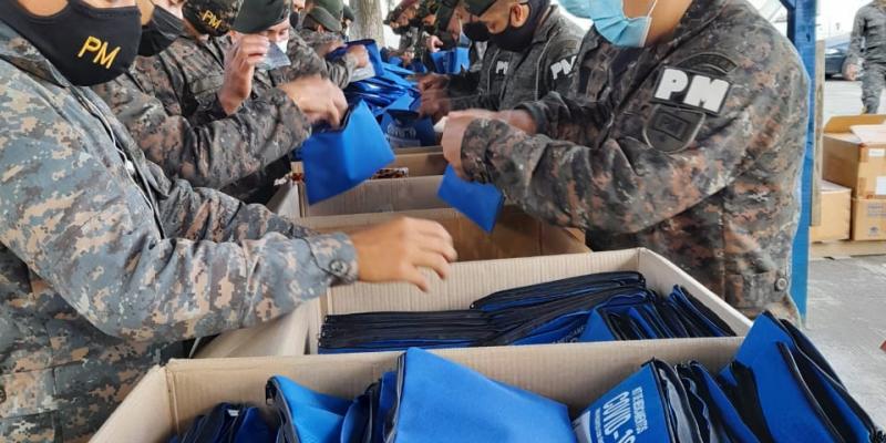 Personal militar embalando kits con medicamentos para pacientes leves con COVID-19