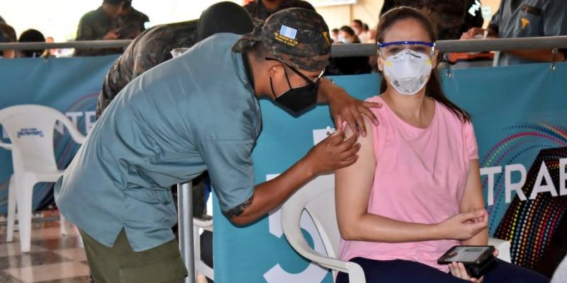 Personal militar coloca vacuna.