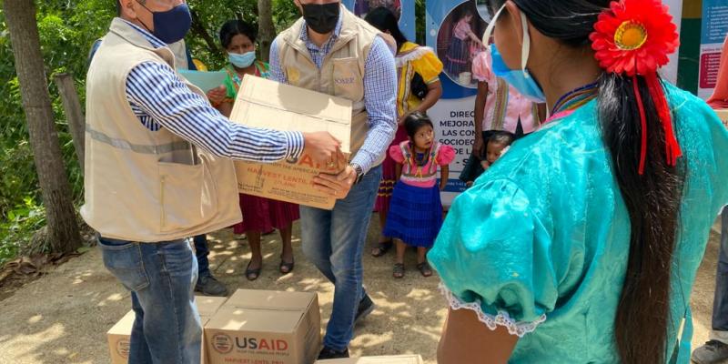 Director de Mejoramiento de las Condiciones Socioeconómicas de la Mujer, José Turtón, entrega una de las cajas con alimentos.