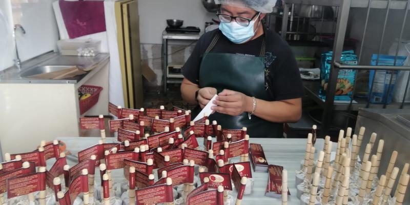 Una operaria elabora chocolate instantáneo cuya particularidad es que posee  su propio molinillo.