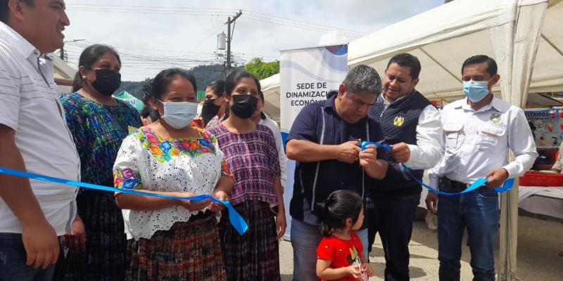 Personas posan para la fotografía en el corte de cinta, inaugurando la feria