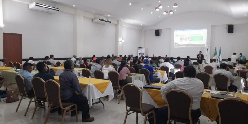 Fotografía en un auditorio con muchas personas, recibiendo una capacitación.