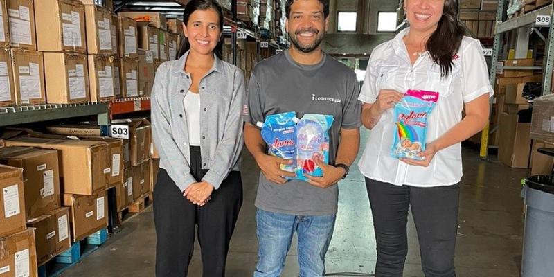 tres personas posan con productos de limpieza en bodega