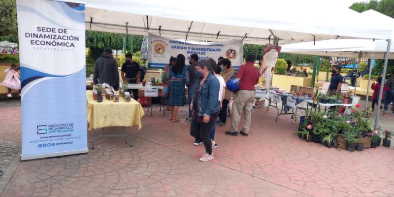 Personas caminan frente a feria de emprendimiento