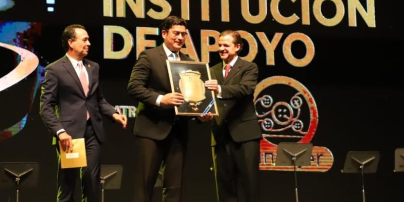 El Ministro de Economía Dr.  Janio Rosales (centro) recibe el reconocimiento.