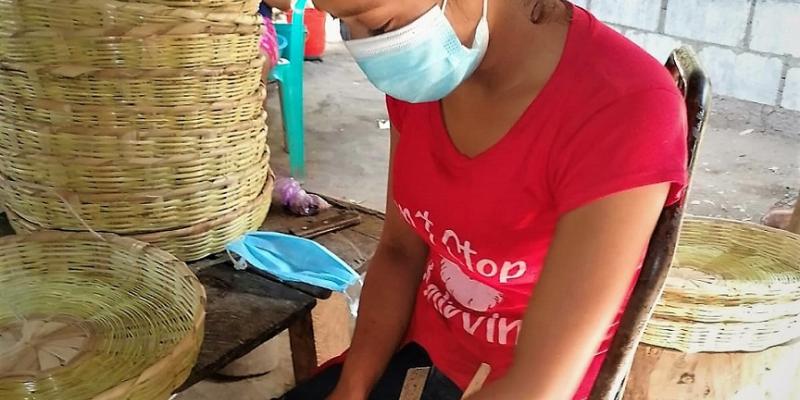 Mujer elabora canastas artesanalmente.