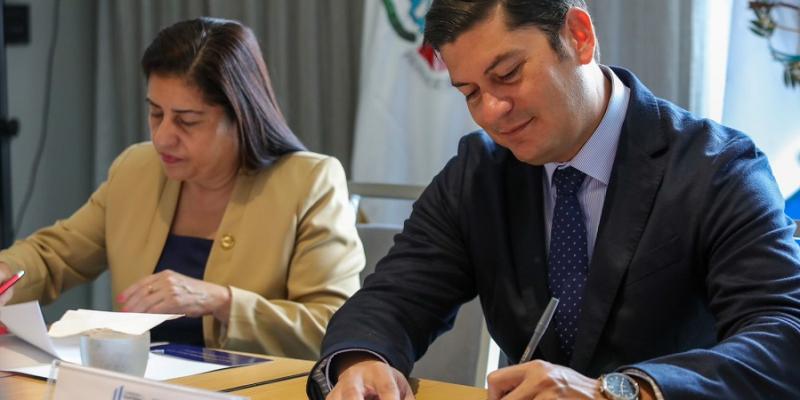 El Ministro de Economía Dr.  Janio Rosales (derecha), durante el momento de la firma con la presidenta de la Junta Directiva de CONADI , Clarivel Castillo Barrientos.