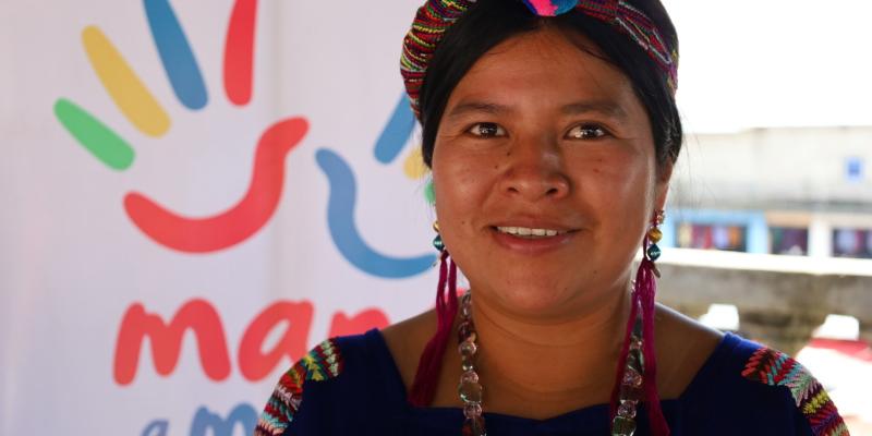 Mujer Indígena con banner institucional.